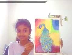 a girl holding up a painting in front of her face