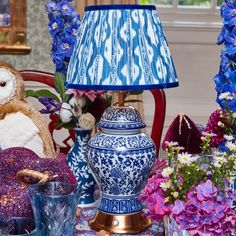 a blue and white table topped with vases filled with flowers