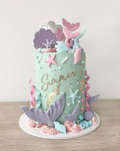 there is a blue cake with pink and purple decorations on it that says summer in the center