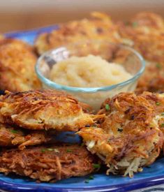 some food on a blue plate with a bowl of mashed potatoes