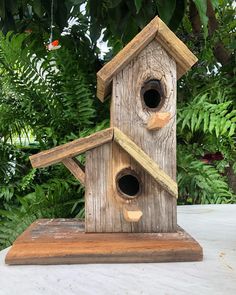 a wooden birdhouse with two holes in the roof