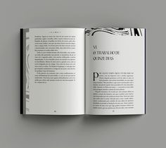 an open book with black and white illustrations on the cover is sitting on a gray surface