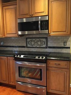 a stove top oven sitting inside of a kitchen next to wooden cabinets and counter tops