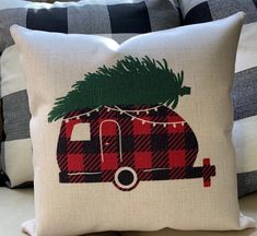 a pillow that has a camper with a christmas tree on it