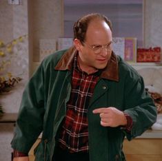 a man pointing at something while standing in a kitchen