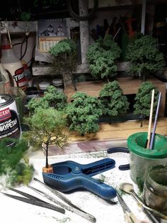 some tools are sitting on a table with trees and other things in the room behind them