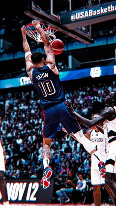 a basketball player dunks the ball in front of two other players during a game