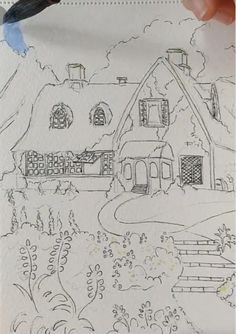 someone is drawing a house on paper