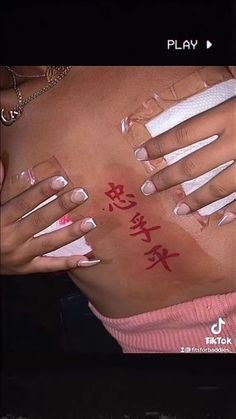 a woman with her hands on the back of her body and writing in red ink