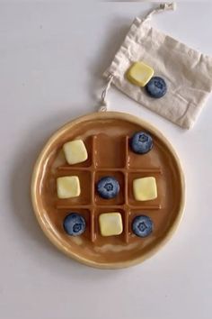 a plate with blueberries and cheese on it next to a bag of wax paper