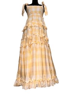 Yellow Plaid Maxi Dress Escape the mundane life and live your cottagecore dreams. Feel the breeze as you twirl and frolic on a prairie field. This dress features a full, ruffled skirt and wide self-tie straps at the shoulders. The lightweight, airy fabric has a plaid pattern of yellow, white and a hint of pink. The upper body is smocked with elastic, which gives a flexible fit. Both the top and skirt of the dress have inner-lining for full coverage and comfort. 100% cotton. Dress is approximatel Mundane Life, Plaid Maxi Dress, The Mundane, Ruffled Skirt, Yellow Plaid, Prairie Dress, Ruffle Skirt, Yellow Dress, Upper Body