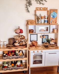 a toy kitchen with wooden shelves filled with food