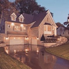 a house that is lit up at night with lights on the front and side of it