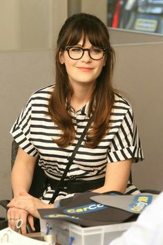 a woman wearing glasses sitting at a desk