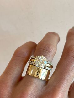 a woman's hand with a gold ring and diamond set on top of it