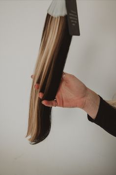 a woman is holding her hair in front of the camera and it looks like she's getting ready to cut it