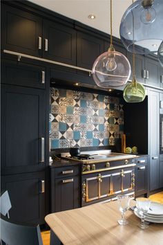 a kitchen with black cabinets and wooden table