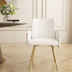 a white chair sitting on top of a hard wood floor next to a wooden table