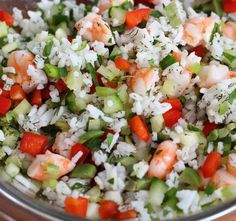 a bowl filled with rice and vegetables on top of a wooden table