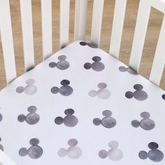 a white crib with mickey mouse bedding on the bottom and black polka dots on the top