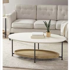 a living room with a couch, coffee table and books on the floor in front of it