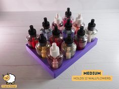 a purple tray holds twelve small bottles with different colored liquids in them and the words medium written below it