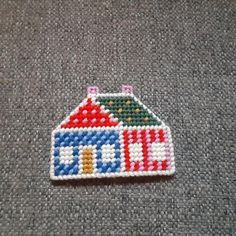 a small beaded house sitting on top of a carpet