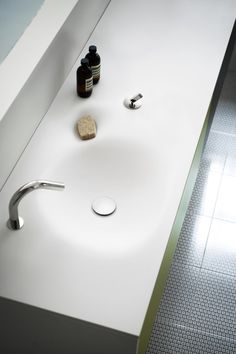 a bathroom sink with soap and lotion on the counter top next to it,