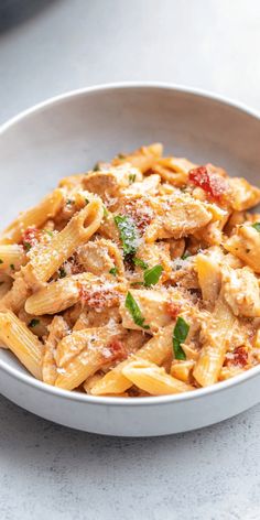 a white bowl filled with pasta covered in sauce