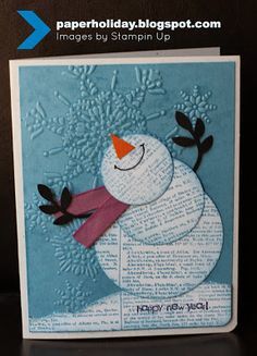 a card with a snowman made out of paper on top of a black table