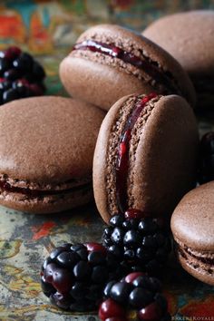 three macaroons are sitting on a table with berries