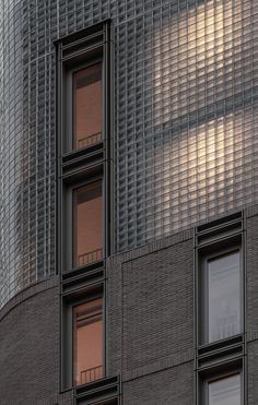 the side of an apartment building with several windows and a clock on it's face