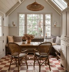 a dining room table with two chairs and a bench in front of the window that is open