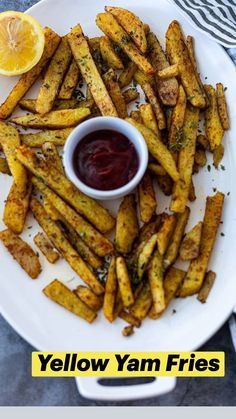 a white plate topped with french fries next to a lemon wedge and ketchup