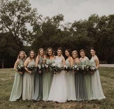 a group of women standing next to each other on top of a lush green field