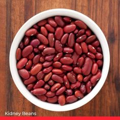 a white bowl filled with red beans on top of a wooden table