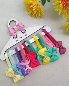 a bunch of colorful hair clips sitting on top of a white table next to yellow flowers