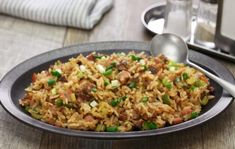 a plate filled with rice and meat on top of a wooden table