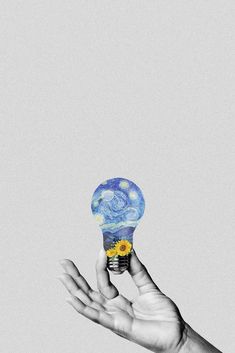 a person's hand holding up a light bulb with the starry night painting on it