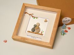 a wooden frame with two pebbles sitting on top of it next to a box