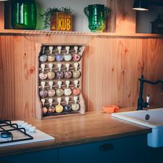 a kitchen with wooden cabinets and shelves filled with vases on top of the counter