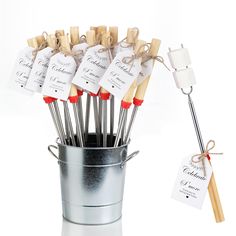 a metal bucket filled with lots of wooden sticks and tags attached to each one's handles