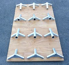 several metal pipes are arranged on a wooden board with holes in the middle to place them