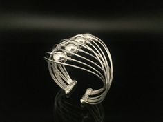 Hi everyone, just wanted to let you know we are open and shipping daily. The silver balls move freely around this wire wrapped sterling silver cuff. Unique and fun to wear. Weight: 22 grams Size: 7 inches Adjustable Silver Bangle With Beads, Adjustable Silver Bangle With Silver Beads, Adjustable Silver Wire Wrapped Cuff Bracelet, Silver Wire Wrapped Bangle Cuff Bracelet, Silver Hand Wrapped Cuff Bracelet, Hand Wrapped Silver Cuff Bracelet, Hand Wrapped Silver Round Cuff Bracelet, Silver Wire Wrapped Cuff Bracelet Gift, Adjustable Silver Cuff Bracelet With Beads