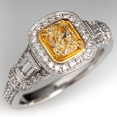 This well crafted ring is centered with one (1) cushion modified brilliant cut diamond set into a four-prong yellow gold accented setting. The ring is also accented with four (4) channel set tapered baguette cut diamonds, and seventy-two (72) bead set round brilliant cut diamonds. The ring measures 10.9mm at the top, rises 7.5mm above the finger, tapering to 2.6mm wide and 1.4mm thick at the base of the shank.  It is crafted in 18k white gold and is currently a size 7.25. Elegant Yellow Baguette Cut Diamond Ring, Formal Yellow Diamond Ring With Single Cut Diamonds, Formal Yellow Diamond Ring With Single Cut, Elegant Yellow Asscher-cut Ring, Elegant Yellow Asscher Cut Ring, Formal Yellow Cushion Cut Diamond Ring, Gia Certified Classic Yellow Diamond Ring, Elegant Yellow Diamond Ring With Single Cut Diamonds, Classic Yellow Diamond Ring With Accents