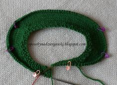 a green crochet hat with two strings and some yarn