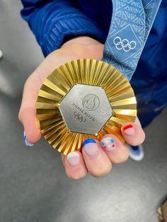 a person holding a gold medal in their hand