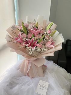 a bouquet of pink flowers sitting on top of a white table next to a mirror