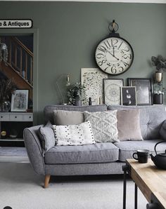 a living room filled with furniture and a large clock on the wall above it's head