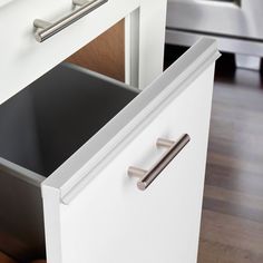 an open drawer in a kitchen next to a dishwasher